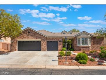Charming single-story brick home with a three-car garage and well-manicured front yard landscaping at 8504 Mystic Night Ave, Las Vegas, NV 89143