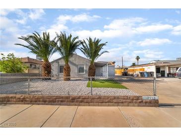 Charming gray single-story home featuring desert landscaping and mature palm trees in the front yard at 113 Elm St, Henderson, NV 89015