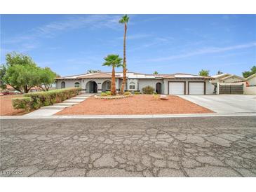 Charming single-story home featuring an attached three-car garage and desert landscaping at 544 N Fogg St, Las Vegas, NV 89110