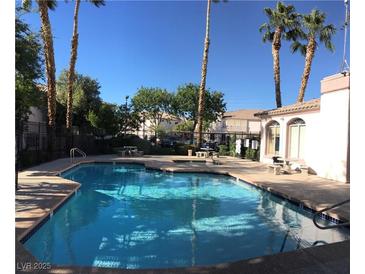 Enjoy the community pool surrounded by palm trees and lounge area at 4555 E Sahara Ave # 226, Las Vegas, NV 89104