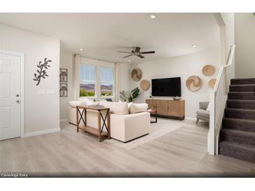 Bright living room featuring modern decor, a comfortable sofa, and scenic views through large windows at 624 Bellus Pl # Lot 170, Henderson, NV 89015