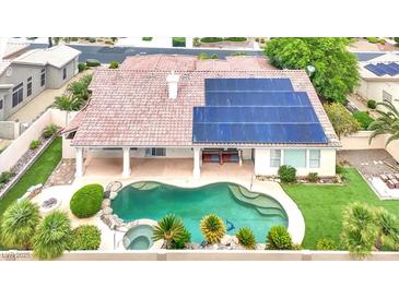Aerial view of the backyard showcasing a private pool, spa, solar panels, and a covered patio at 7511 Bridlehorne Ave, Las Vegas, NV 89131