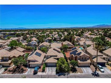Residential neighborhood with single-Gathering homes, many with solar panels, and mountain views in the distance at 7625 Raven Hills Dr, Las Vegas, NV 89149