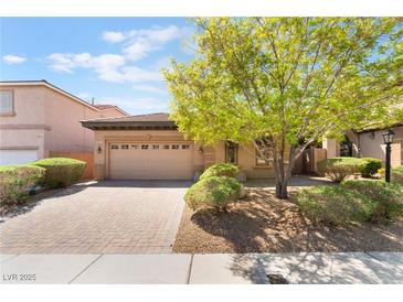 Charming home featuring a well-manicured yard, mature tree, and a brick driveway leading to a two-car garage at 9025 Loggers Mill Ave, Las Vegas, NV 89143