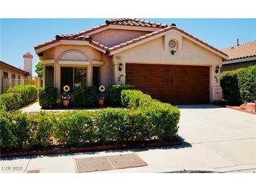 Charming single-story home featuring a well-manicured front yard and a wood-paneled two-car garage at 9355 W Viking Rd, Las Vegas, NV 89147