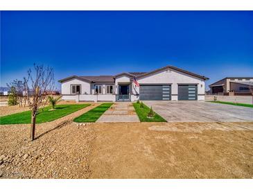 Charming single-story home featuring a modern design with a well-manicured lawn and spacious driveway at 2650 Underbrush Ave, Pahrump, NV 89048
