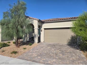 Charming single-story home featuring a desert landscape, brick driveway and a neutral stucco exterior at 4719 N Transcendental St, North Las Vegas, NV 89031