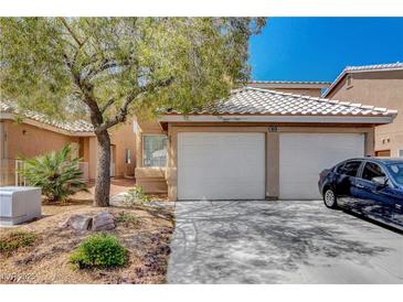 Charming townhome featuring a two-car garage, desert landscaping, and a tile roof at 8048 Astrology Ct # 201, Las Vegas, NV 89128