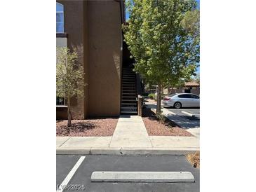 Apartment building exterior with staircase, landscaping, and parking spot visible in the foreground at 9000 Las Vegas Blvd # 2189, Las Vegas, NV 89123