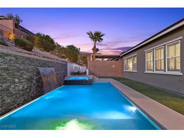 A luxurious pool with a waterfall feature and a spa, perfect for relaxation and outdoor enjoyment at 18 Via Tiberina, Henderson, NV 89011