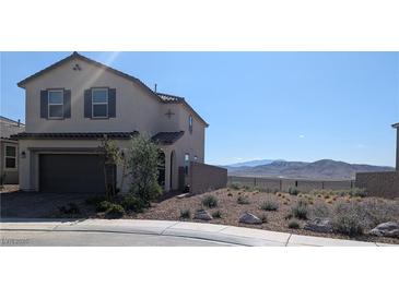 Charming two-story home with stucco siding, a two-car garage, and beautiful desert landscaping in front at 2343 Teatro Ave, Henderson, NV 89044
