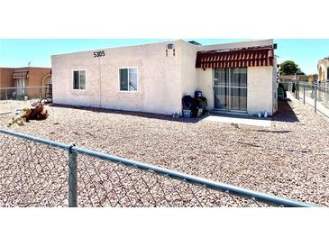 Modest single-story home featuring a fenced gravel front yard, light stucco walls, and a small covered patio at 5305 W Cheyenne Ave, Las Vegas, NV 89108