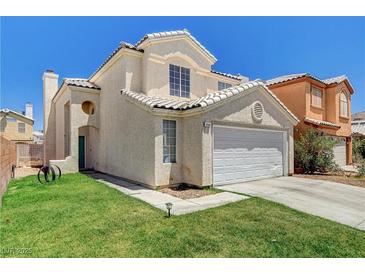 Charming two-story home with a well-maintained lawn, a two car garage and desert landscaping at 6058 Grape Blossom Ave, Las Vegas, NV 89142
