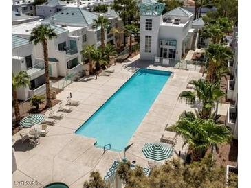 Resort style community pool with palm trees and lounge chairs create a relaxing outdoor space at 7100 Pirates Cove Rd # 1099, Las Vegas, NV 89145