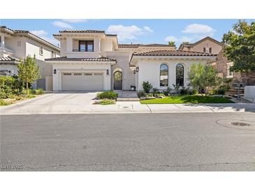 Stunning two-story home featuring a tile roof, arched entry, and a manicured front lawn at 1990 Country Cove Ct, Las Vegas, NV 89135