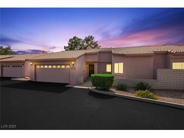 Inviting single-story home featuring a well-manicured lawn, attached garage, and charming curb appeal at 615 Cervantes Dr, Henderson, NV 89014