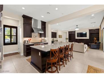 Open kitchen featuring an island with bar seating, modern appliances, and dark cabinetry at 6810 Silver Crescent St, Las Vegas, NV 89148
