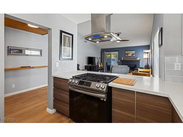Modern kitchen featuring stainless steel range and hood, quartz countertops, and wood cabinets at 8509 Lansdale Rd, Las Vegas, NV 89123