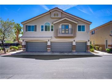 Charming two-story home featuring three-car garage, complemented by stucco facade and balcony detail at 10062 Aspen Rose St # 103, Las Vegas, NV 89183