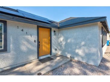 Charming home featuring a bright yellow front door and modern solar panels at 1411 Norman Ave, Las Vegas, NV 89104