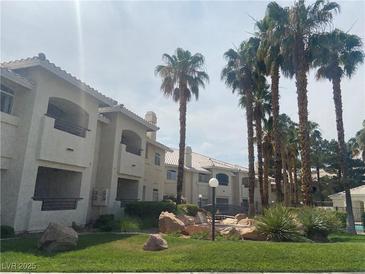 Beautiful Condo Community with palm trees, grass, and well maintained landscaping with an attractive entrance and inviting design at 3320 S Fort Apache Rd # 139, Las Vegas, NV 89117