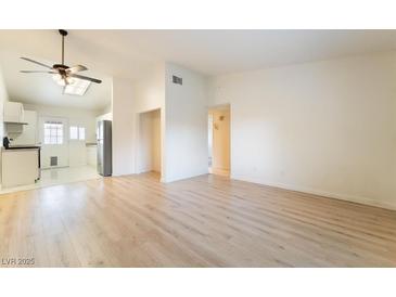 Bright living room with hardwood floors and an open floor plan to the kitchen at 4274 Rollingstone Dr, Las Vegas, NV 89103