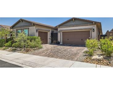 Beautiful single-Gathering home featuring a meticulously landscaped front yard and a paved driveway leading to two-car garages at 704 Webber Park St, Henderson, NV 89011