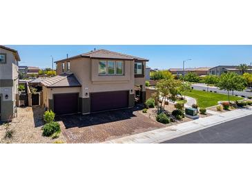 Two-story stucco home with a two-car garage and landscaped front yard in a suburban neighborhood at 7824 Warm Winds St, North Las Vegas, NV 89084