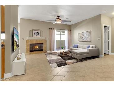 Bright living room with fireplace, tile floors, ceiling fan, and sliding door to the outside at 108 Lemon Glaze St # 202, Las Vegas, NV 89145