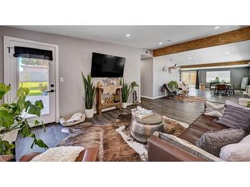 A stylish living room with a leather sofa, plants, and wood-look flooring offers comfortable living at 3013 Roseville Way, Las Vegas, NV 89102