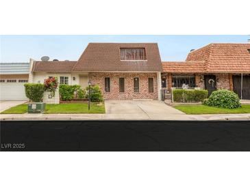 Charming brick home featuring a unique architectural design and well-maintained front yard at 3471 One Nation Ave, Las Vegas, NV 89121
