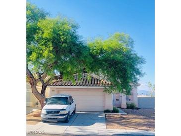 Charming single-story home with a well-maintained front yard and a large shade tree at 7528 Golden Yucca Dr, Las Vegas, NV 89147