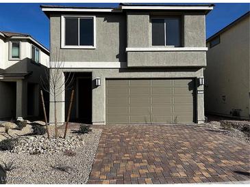 Charming two-story home featuring a brick driveway and a neutral-colored exterior with an attached two-car garage at 8020 Texas Hills St, Las Vegas, NV 89113