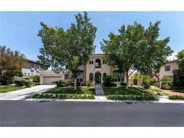 Charming two-story stucco home featuring desert landscaping, arched entry, and a two-car garage at 1204 Moselle Ct, Las Vegas, NV 89144