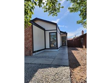 Charming single-story home showcasing modern architectural style with a brick accent and a well-maintained yard at 2318 El Molino Cir, Las Vegas, NV 89108