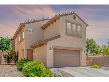 Two-story home features a neutral-colored exterior, attached garage, and desert landscaping at 389 Fringe Ruff Dr, Las Vegas, NV 89148
