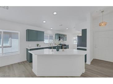 Bright kitchen featuring green cabinets, white marble countertops, and stainless steel appliances at 4369 Meadowlark Wing Way, North Las Vegas, NV 89084