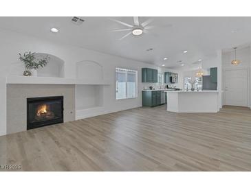 Bright open-concept living room with fireplace and views into kitchen featuring a modern design at 4369 Meadowlark Wing Way, North Las Vegas, NV 89084