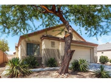Charming one-story home featuring desert landscaping, an attached two-car garage, and stucco walls at 5605 Midnight Breeze St, North Las Vegas, NV 89081