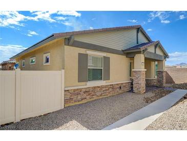 Tan single story home with stone accents, low maintenance yard, and desert landscaping at 794 Sunny Sagebrush St, Henderson, NV 89011