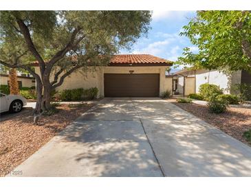 Charming home featuring a spacious driveway and a two-car garage with a well-maintained front yard at 2857 San Lago Ct, Las Vegas, NV 89121
