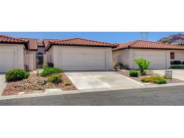 Charming townhome featuring a tile roof, two-car garage, and low-maintenance landscaping in a desirable community at 445 Intrepid Ct, Boulder City, NV 89005