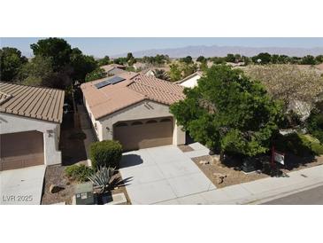 Inviting single-story home featuring a two-car garage, desert landscaping, and solar panels at 5439 E Cansano St, Pahrump, NV 89061