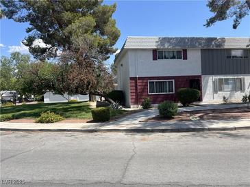 Charming townhome exterior featuring mature trees and a well-maintained landscaped front yard at 565 Greenbriar Townhouse Way, Las Vegas, NV 89121