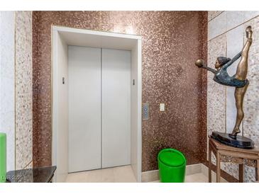 Private elevator access with mosaic tile walls and interesting art sculptures at 9101 Alta Dr # 203, Las Vegas, NV 89145