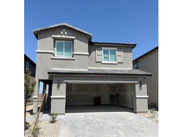 Charming two-story home with a two-car garage and stone accents against a bright blue sky at 10406 Luna Mezza Ave # Lot 192, Las Vegas, NV 89141