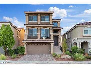 Charming three-story home showcasing a private balcony, low-maintenance landscaping, and a two-car garage at 6056 Atlantis Dream Ave, Las Vegas, NV 89139
