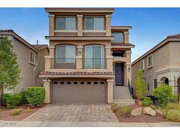 Charming three-story home featuring a balcony, two-car garage, and desert landscaping at 6056 Atlantis Dream Ave, Las Vegas, NV 89139