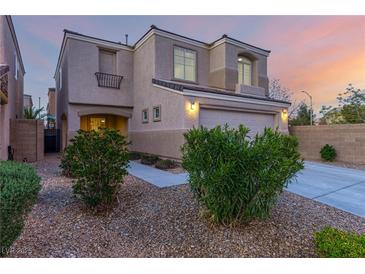 Attractive exterior view of home featuring a two-car garage, landscaped yard, and neutral color palette at 9006 Cedar Door Ave, Las Vegas, NV 89148