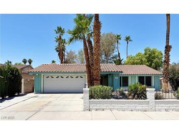 Charming single-story home with a two-car garage, tile roof, mature landscaping, and appealing curb appeal at 349 Esquina Dr, Henderson, NV 89014
